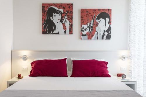 a bedroom with a white bed with red pillows at Viva Vacanze in Porto Cesareo