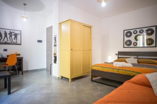 a bedroom with a yellow cabinet and a bed at Hello World in Agrigento