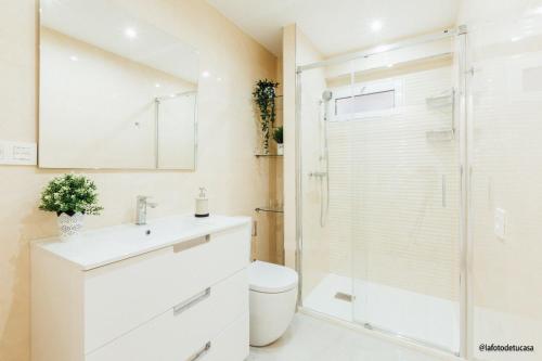 ein Badezimmer mit Toilette und Glasdusche in der Unterkunft Apto. Jesuitas in Gijón