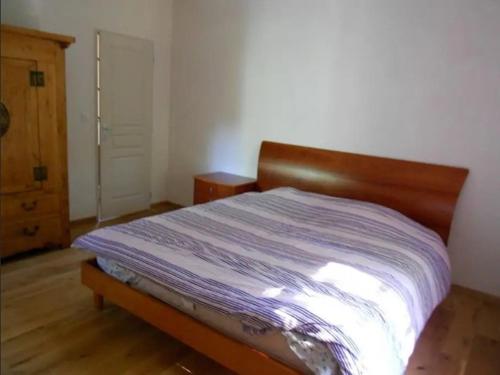 a bedroom with a bed with a wooden head board at Mas Ferrieres Saint Laurent in Saint-Laurent-le-Minier