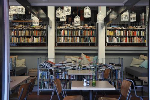 a library with tables and chairs and books at Hotel Credible in Nijmegen