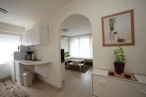 a room with a kitchen and a living room at Siesta Apartmanház Balatonfüred in Balatonfüred