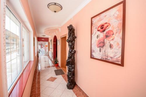 a hallway with pink walls and a painting on the wall at Hotel Drumski Raj in Svilajnac