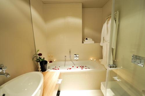 a white bathroom with a tub and a sink at Stage47 in Düsseldorf