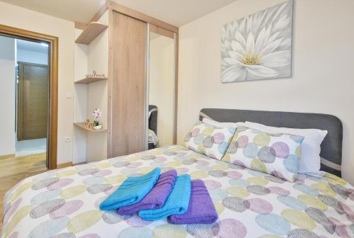 - une chambre avec un lit et des serviettes dans l'établissement Apartman Alex Zlatibor, à Zlatibor
