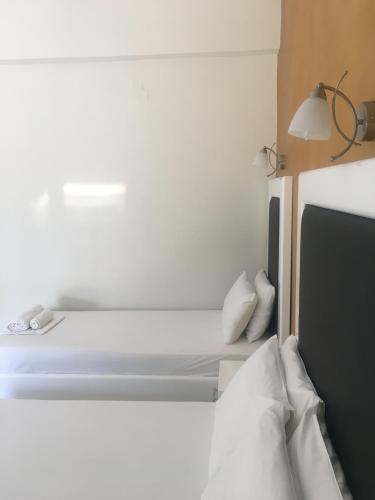 a bedroom with a bed with white sheets and pillows at Spiros Rooms in Kastrosikia