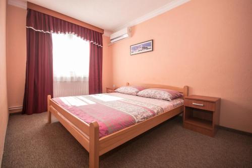 a small bedroom with a bed and a window at Hotel Drumski Raj in Svilajnac