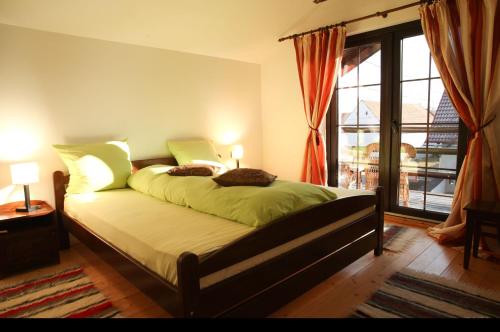 a bedroom with a bed with green sheets and a window at Casa Mosului - Transfăgărășan Bed & Breakfast in Cîrţişoara
