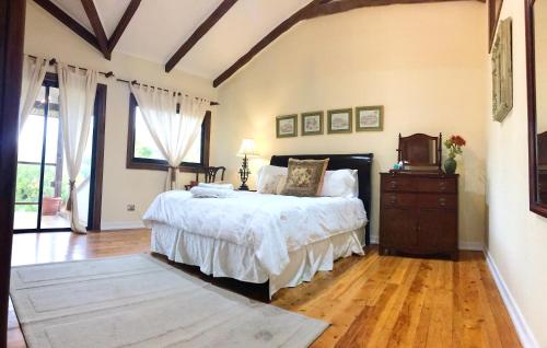 una camera con un grande letto e un pavimento in legno di South Landing Inn a Los Ángeles