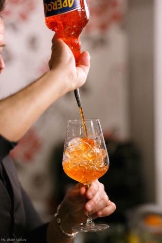 a woman is holding a drink in a glass at The One Hotel - Designed for Adults - Pet lovers in Riccione