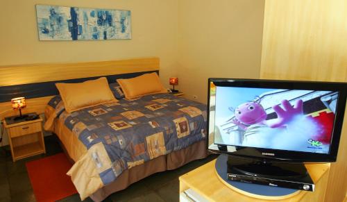 a bedroom with a bed and a television on a table at Hotel Fazenda Reviver in Araçoiaba da Serra