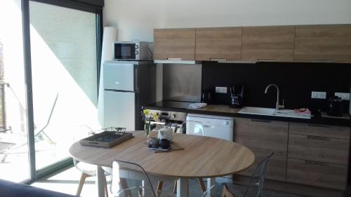 une cuisine avec une table en bois et une table et des chaises dans l'établissement Gites du pech cathare, à Leychert