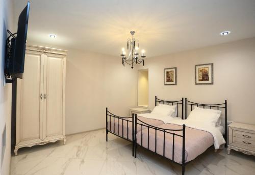 sypialnia z łóżkiem, telewizorem i żyrandolem w obiekcie OLD CORNER w mieście Tbilisi City
