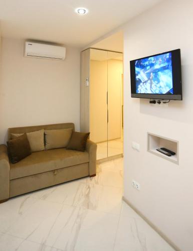 een woonkamer met een bank en een flatscreen-tv bij OLD CORNER in Tbilisi City