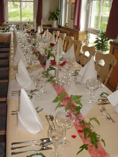 a long table with wine glasses and flowers on it at Waldhotel Forsthaus Remstecken in Koblenz