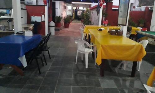 a restaurant with yellow tables and chairs and a pool table at Pousada olho d'água in São Luís