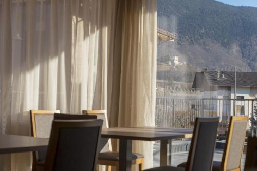 a dining room with a table and chairs and a window at Agritur Piccolo Fiore B&B in Taio