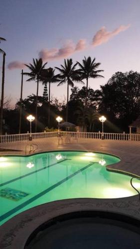 a swimming pool at night with palm trees in the background at La Toscana in Chinauta