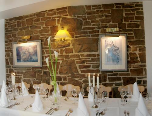 a dining room with a table with glasses and candles at Waldhotel Forsthaus Remstecken in Koblenz