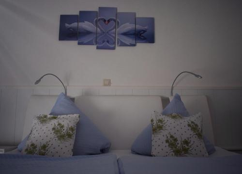 a couch with two pillows and a painting on the wall at Hotel zum Goldenen Wagen in Maulburg