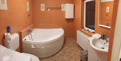 a bathroom with a tub and a toilet and a sink at Strigonia Apartman in Esztergom