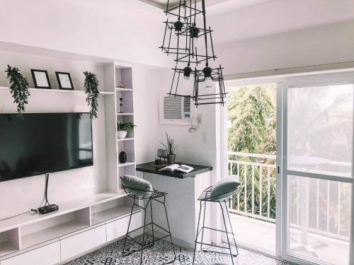 a living room with a large television and two stools at Soderberg ( Near Airport | 50mbps Wifi | Netflix ) in Mactan