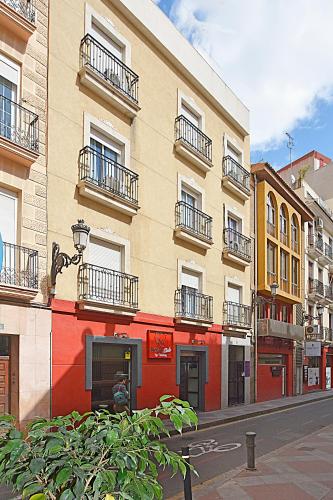 a building with balconies on a city street at Apartamentos Plaza,viviendas turisticas in Alicante