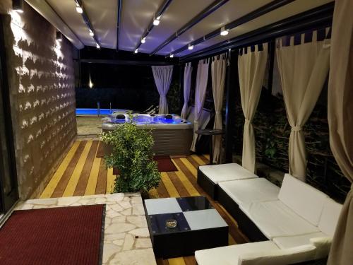 a room with two white couches and a tub at Villa Summer dream with heated pool, sauna and jacuzzi in Malinska
