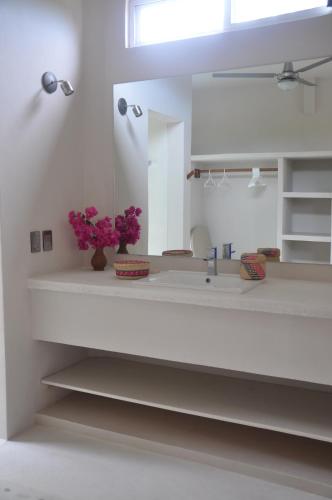 a bathroom with white walls and stairs with purple flowers at Casa Cometa in San Agustinillo