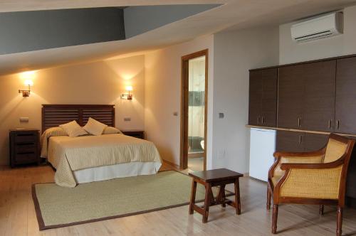 a bedroom with a bed and a table and a chair at Casa Rural La Botica in Oropesa