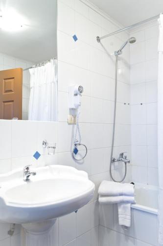 a white bathroom with a sink and a shower at Weisserhaus in Puerto Varas