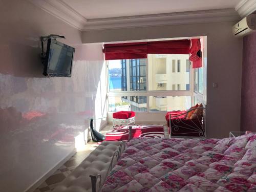 1 dormitorio con 1 cama, TV y ventana en la baie de Tanger, en Tánger