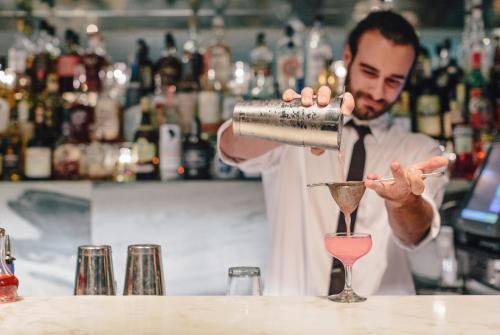 a man pouring a drink into a martini glass at Avalon Hotel Beverly Hills, a Member of Design Hotels in Los Angeles