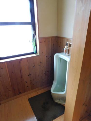 a bathroom with a green urinal and a window at Nouka Minsyuku Hyousa in Minamiechizen