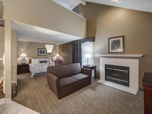 een woonkamer met een stoel en een open haard bij Eastland Suites Extended Stay Hotel & Conference Center Urbana in Champaign
