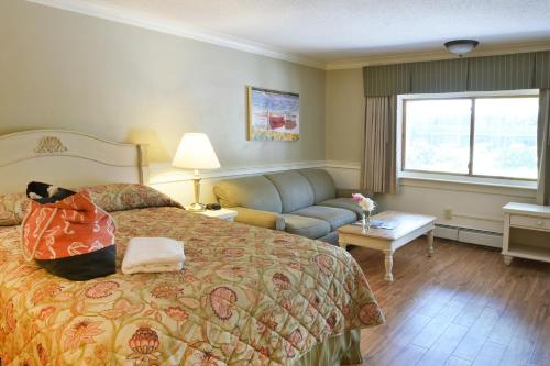 Habitación de hotel con cama y sofá en The Cove Motel, en Orleans