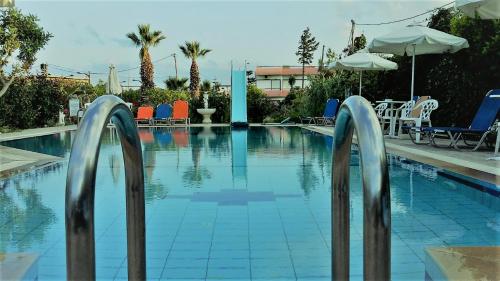 a swimming pool with two metal bars in the water at Violetta Hotel in Amoudara Herakliou
