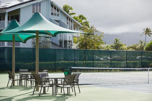 a tennis court with tables and chairs and a tennis racket at The Cliffs at Princeville in Princeville