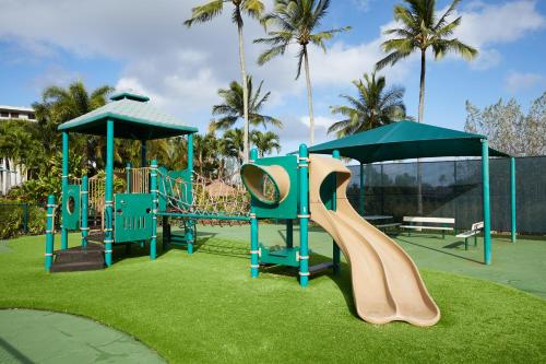 a playground with a slide in a park with palm trees at The Cliffs at Princeville in Princeville