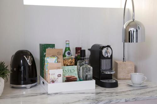 a table with a coffee maker and a bottle of wine at Avalon Hotel Beverly Hills, a Member of Design Hotels in Los Angeles