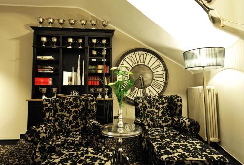 a living room with two chairs and a clock at Stage47 in Düsseldorf