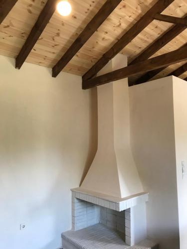 a fireplace in a living room with wooden ceilings at Taygetos in Sparti