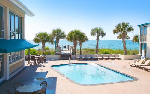 a swimming pool with a view of the ocean at Oceanfront Litchfield Inn in Pawleys Island