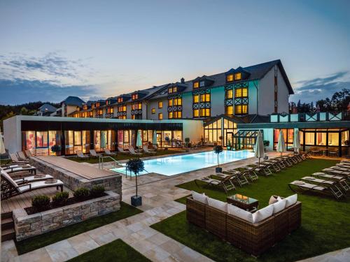 a hotel with a swimming pool and a resort at Land & Golf Hotel Stromberg in Stromberg