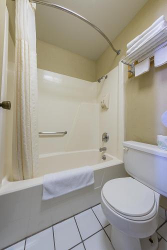 a bathroom with a toilet and a tub and a sink at Americas Best Value Inn - Legend's Inn in Junction