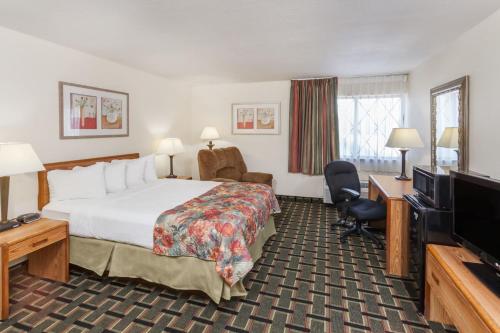 a hotel room with a bed and a flat screen tv at Baymont by Wyndham Decatur in Decatur