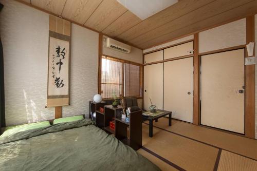 a room with a bed and a desk in a room at Close to Golden temple -Kinkakuji- in Kyoto
