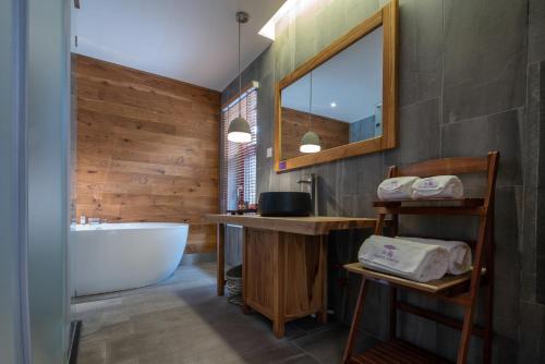 a bathroom with a tub and a sink and a mirror at The Apsara Lodge-Airport or TS Free pick-up over 3 nights in Yangshuo