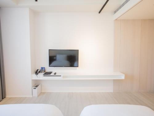 a white room with a tv on a white wall at The Place Taichung in Taichung