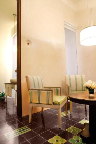 a living room with two chairs and a table at Rosas & Xocolate Boutique Hotel and Spa Merida, a Member of Design Hotels in Mérida